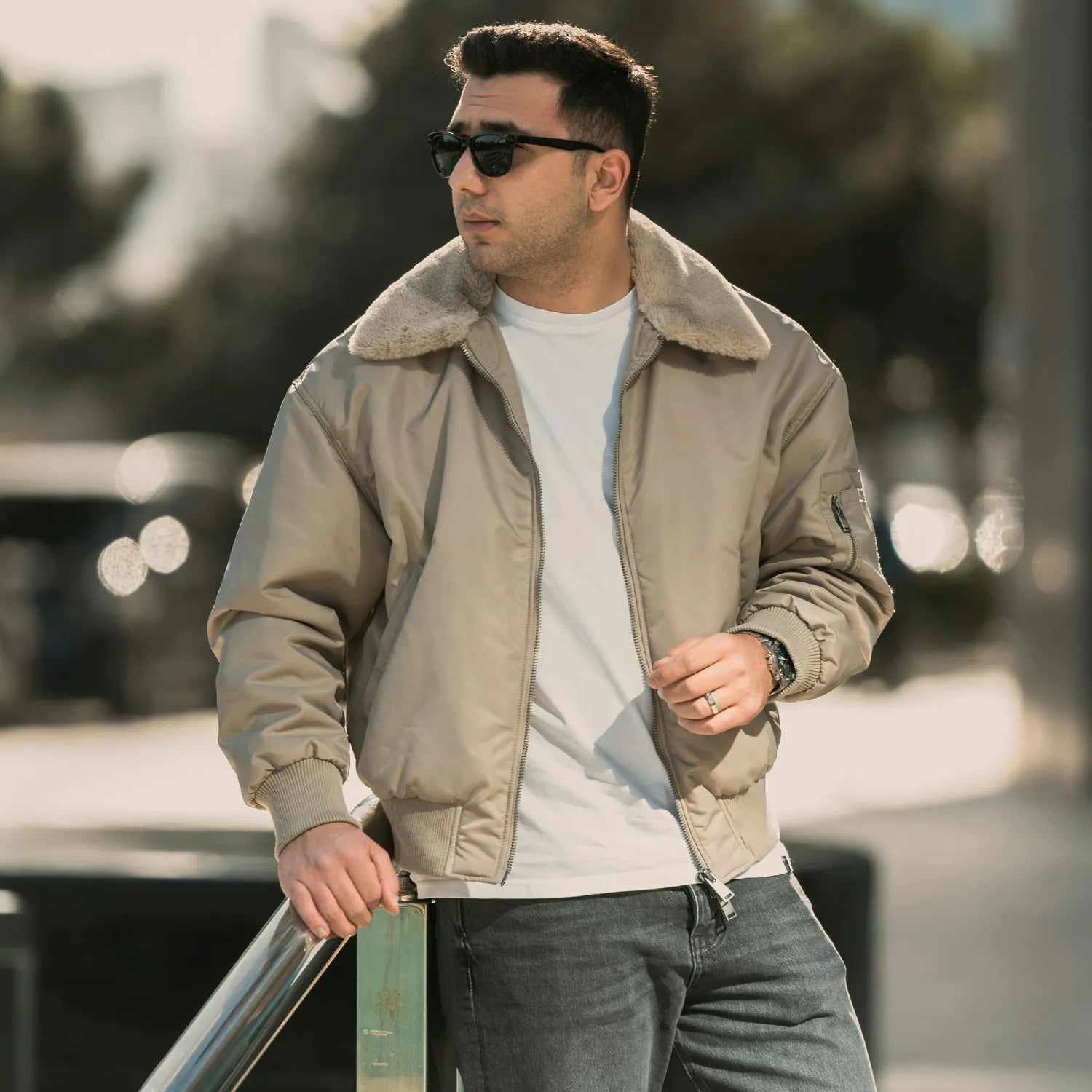 Person wearing a light-colored jacket and white t-shirt in an urban area. basic clothes 