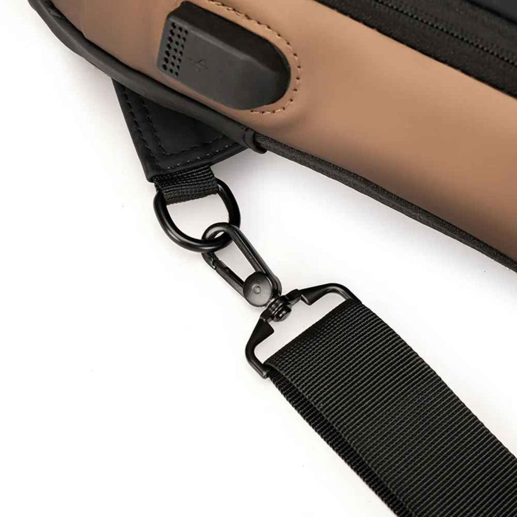 USB cable connected to the charging port of the Basic Clothes Co. crossbody bag, demonstrating on-the-go charging